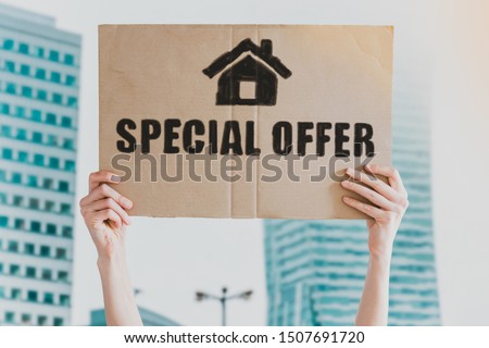 The phrase " Special Offer " and home icon drawn on a carton banner in men's hand. Human holds a cardboard with an inscription: Special Offer. Real-estate sale discounts