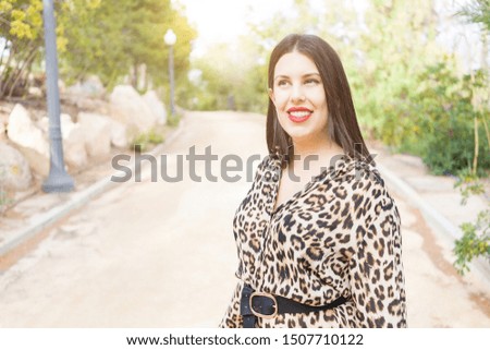 Young beautiful woman with red lips smiling happy at garden