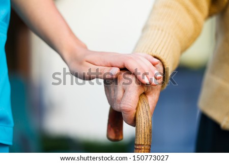 Doctor holding a senior patients 's hand on a walking stick - special medical care concept for Alzheimer 's syndrome. Royalty-Free Stock Photo #150773027