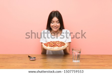 Young woman with a pizza in a table