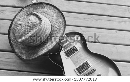 electric guitar  and cowboy hat on the wooden boards at the country barn                            