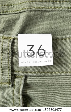 36 size clothes label on khaki green denim background