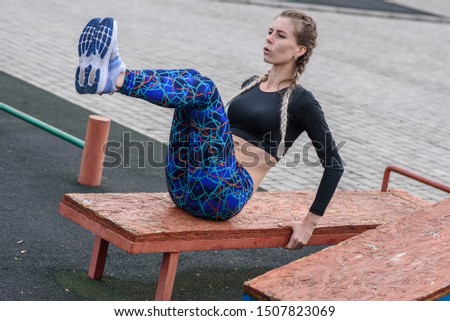 Sporty girl doing abs exercises on the playground