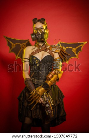 Actress woman masked and dressed as fictional fantasy characters steampunk posing on red background