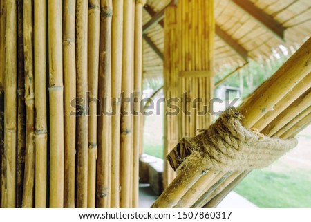 Many bamboo bindings are tied together with hemp ropes to be used as pole for resting cottage. Selective focus on hemp ropes.