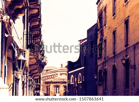 Traditional architecture of Sicily in Italy, typical street of Catania, facade of old buildings on sunset
