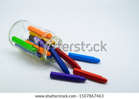Colourful school supplies, stationery markers in a transparent jar isolated on white background - space for caption