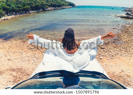 woman laying at car hood with view of sea summer beach vacation copy space