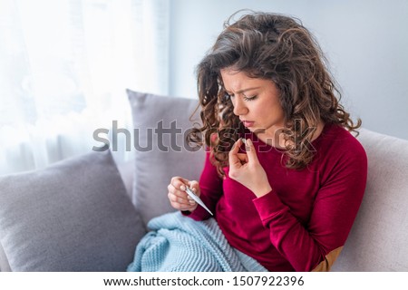 Young woman sick with colds and flu, self-medication at home with vitamins and pills. suffering from the nose due to allergies. Woman having high fever and suffering from strong headache during flu Royalty-Free Stock Photo #1507922396