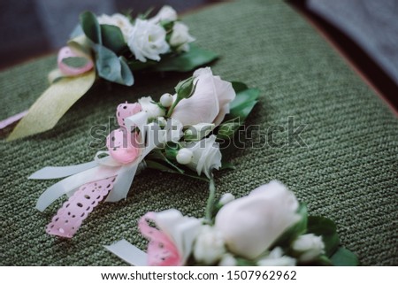 close up of beautiful modern wedding boutonniere of white flowers rose on a chair. Wedding details and a natural concept. Top view