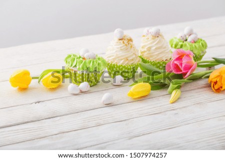 Easter cupcakes on white wooden table