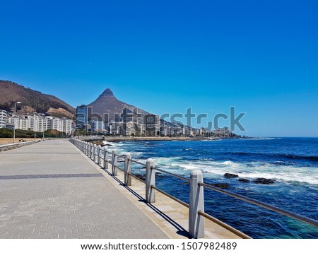 Mountains, hotels and deep blue water with waves at the Sea Point, beach promenade in Cape Town South Africa. Royalty-Free Stock Photo #1507982489
