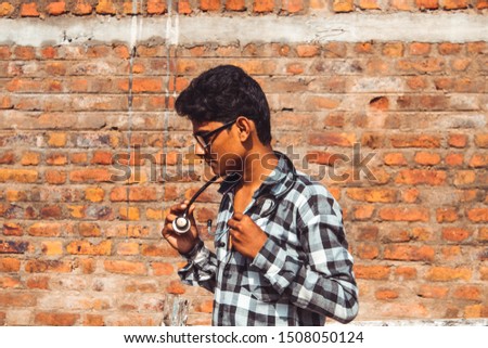 Indian man wearing glasses and stethoscope around his neck staring at the camera