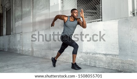 African american male athlete sprinter, running at a high speed in urban concrete city background with copy space Royalty-Free Stock Photo #1508055701