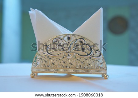 Hotel dining table with Decorative Napkin, glass tableware in Hotel dining room .blur image - White paper napkin is placed in a glass on the table in the banquet room.