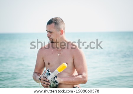 Man with swiming mask in the hand is going goes on water