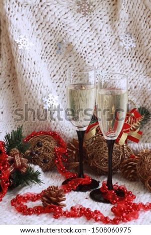 New Year's festive picture with glasses of champagne, Christmas toys, green spruce branches, red beads and hearts. 2019