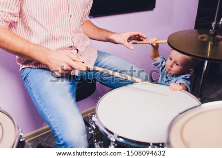 little boy plays drums in recording studio.