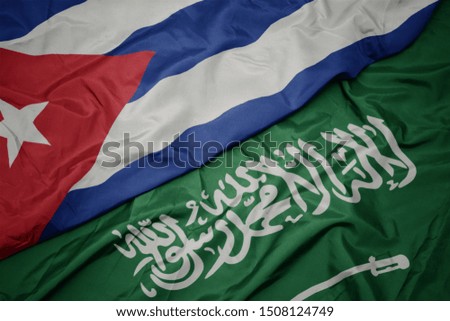 waving colorful flag of saudi arabia and national flag of cuba. macro