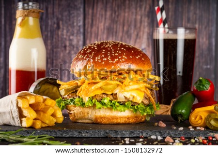 Hamburger with french fries and cola on stone table with wooden background