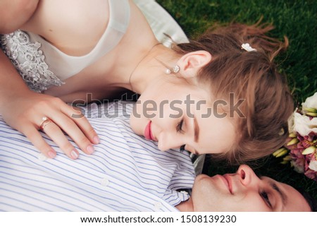 
boyfriend and girlfriend are lying on the grass