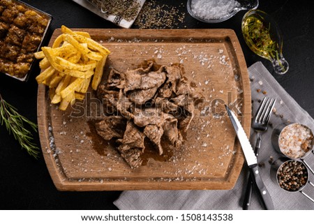 Grilled steak on wooden cutting table with salt and paper