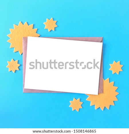 Blank postcard mockup with yellow felt stars and blue background. Flat lay mockup for greeting cards, invitations, flyers, prints, leaflets, stationery paper, letters. Colorful product thumbnails.