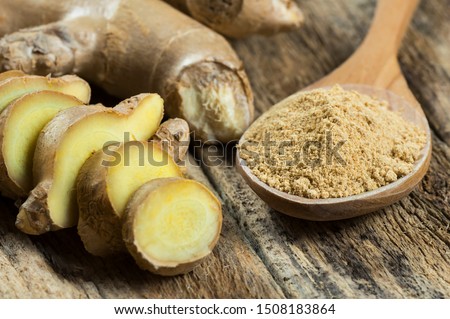 Fresh chopped ginger root and ground ginger powder in wooden spoon on wooden rustic table. Healthy food spice concept. Zingiber officinale Royalty-Free Stock Photo #1508183864