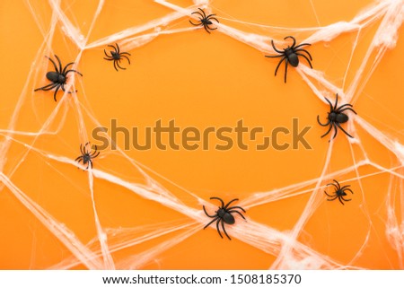 Halloween background with spider web and spiders as symbols of Halloween on the orange background. Happy Halloween concept. Frame