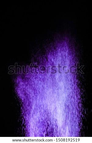 Multicolored particles explosion on black background. Colorful dust splatter on black background.
