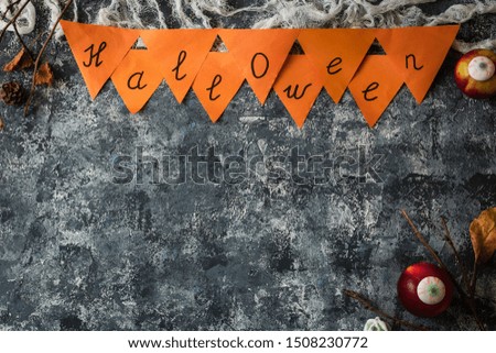 Creative Halloween background with dry branches, autumn leaves and creepy marshmallow sweets. Top view. Place for text.