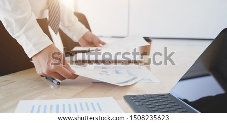 Young professional businessman preparing the financial reports for the meeting in his modern office room 