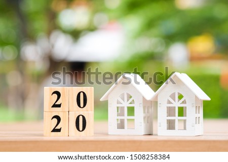 Two house and 2020 wooden blocks number. New year property investment concept.