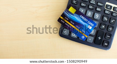 Credit card for pay with black calculator on wood table. copy space for Banner design