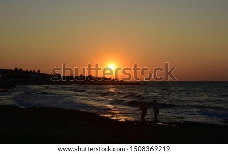 Orange-colored beach on the Greek island at sunset.