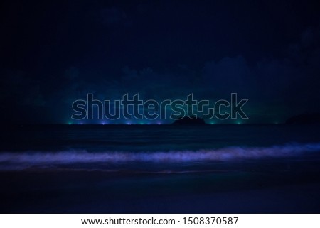 the concept of landscape design, lighting, travel: sea waves, water illumination against the night sky
