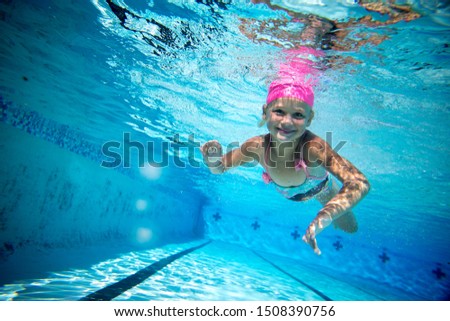 a young girl swimming free underwater in a swimmingpool