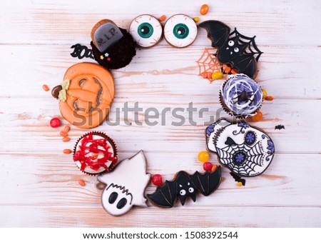Halloween party decoration concept. Halloween gingerbread cookies on a wood background.