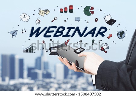Business webinar concept with man using digital tablet and hand drawn webinar word at blurry city background.Double exposure.