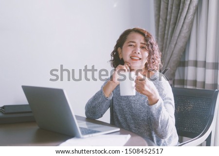 Happy Elderly Asian woman using laptop in bedroom at the morning.