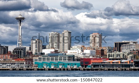 Seattle waterfront and skyline under dramatic dark clouds
