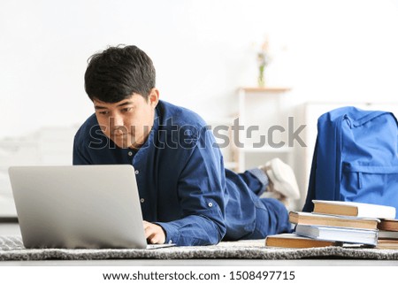 Asian student with laptop preparing for exam at home
