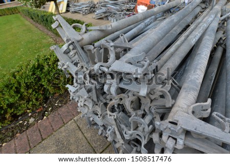 Metal scaffolding poles piled up ready to construct up the side of a building 