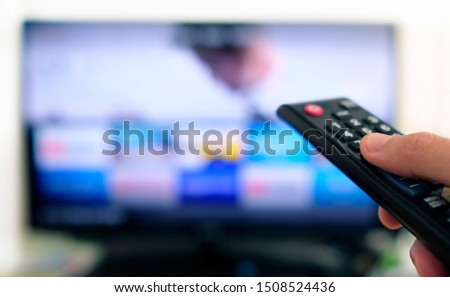 Remote control and screen - binge watching the favorite TV show Royalty-Free Stock Photo #1508524436