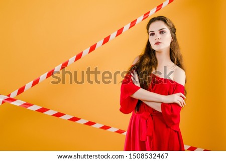 young pretty woman with signal tape isolated over yellow