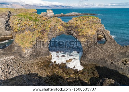 Beautiful scenic view of basalt arch rock Gatklettur at the Atlantic coast of Arnarstapi at Snæfellsnes Peninsula in Iceland is very popular for photographers and tourists.