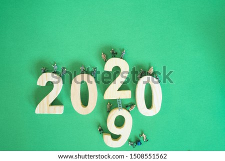 labor or miniature technicians working. New year 2019 change to 2020 concept on green paper background