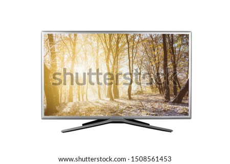 4K monitor or TV with the image of sunrise in the autumn forest with the first snow on the screen isolated on white background