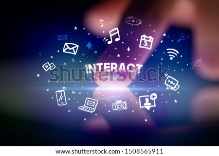 Finger touching tablet with drawn social media icons and INTERACT inscription, social networking concept