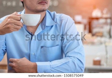 Businessman is holding a cup of coffee